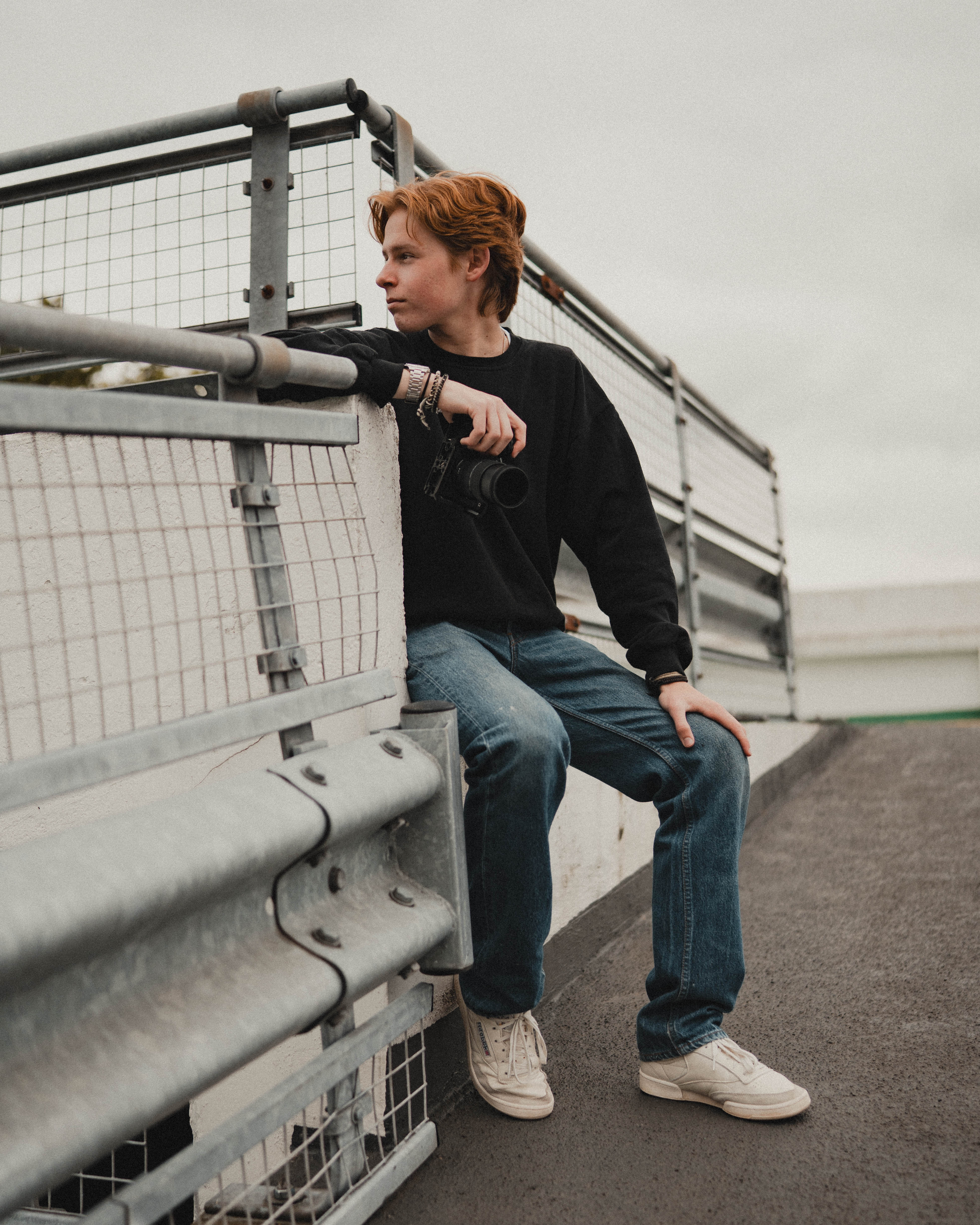 Bryce Edginton holding a camera beside a railing